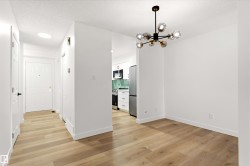 Modern open-concept interior featuring light wood-finish flooring throughout - 
