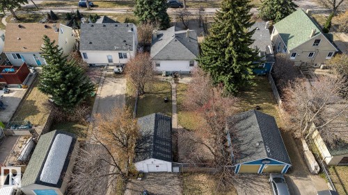 Aerial property overview featuring multiple detached homes, mature trees, a paved driveway, and detached garages - 12235 104 Street Nw, Edmonton, AB - Outdoor