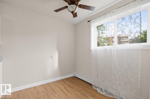 Room featuring light wood-finish flooring and neutral wall tones - #5 11265 31 Av Nw, Edmonton, AB - Indoor Photo Showing Other Room