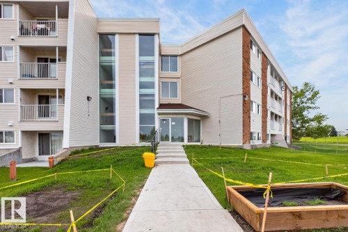 Multi-story building featuring light-colored siding, brick accents, and multiple balconies - #5 11265 31 Av Nw, Edmonton, AB - Outdoor With Facade