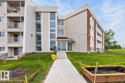 Multi-story building featuring light-colored siding, brick accents, and multiple balconies - 