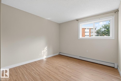 Room featuring wood-finish flooring, neutral wall paint, and white trim - #5 11265 31 Av Nw, Edmonton, AB - Indoor Photo Showing Other Room