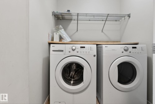 Dedicated laundry area featuring a front-load washer and dryer, a durable countertop surface, and an overhead wire shelving unit - 96 Dalquist Bay, Leduc, AB - Indoor Photo Showing Laundry Room