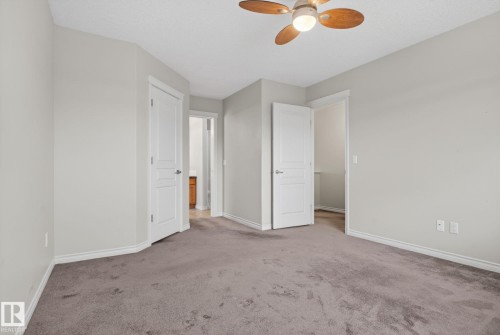 Carpeted room with a ceiling fan light fixture, light gray walls, white trim, and white paneled doors - 96 Dalquist Bay, Leduc, AB - Indoor Photo Showing Other Room