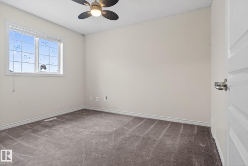 Bedroom featuring neutral-toned walls, grey carpeting, a multi-pane window, and a ceiling fan with integrated lighting - 96 Dalquist Bay, Leduc, AB - Indoor Photo Showing Other Room