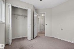 Carpeted room featuring a window, bi-fold closet doors, wall-mounted wire shelving, and a panel door - 