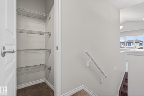 Interior closet with wire shelving, carpeted floor, and white paneled door - 96 Dalquist Bay, Leduc, AB - Indoor With Storage