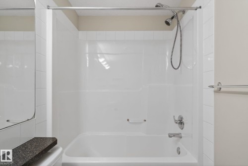 Bathtub and shower combination featuring a white surround, chrome showerhead with hose, and chrome fixtures - 96 Dalquist Bay, Leduc, AB - Indoor Photo Showing Bathroom