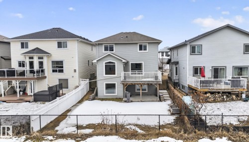 Rear exterior featuring a spacious deck with white railings, light gray siding, and a walk-out lower level - 96 Dalquist Bay, Leduc, AB - Outdoor With Deck Patio Veranda