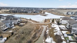 Aerial perspective showcasing a residential community bordering a large body of water - 