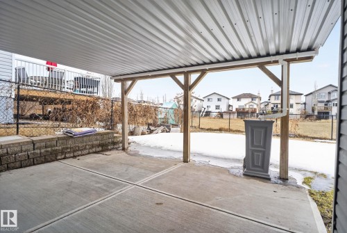 Covered patio featuring a sturdy wood-beam pergola structure with corrugated metal roofing, anchored by substantial timber posts - 96 Dalquist Bay, Leduc, AB - Outdoor