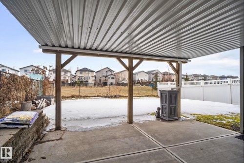 Covered patio with a corrugated metal roof supported by wooden posts - 96 Dalquist Bay, Leduc, AB - Outdoor