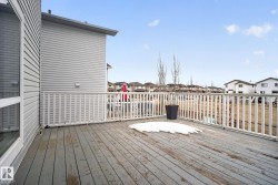 Expansive wood-finish deck with white railing system - 