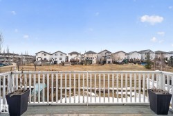 Expansive wood deck featuring a white spindle railing - 