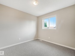 Neutral painted walls with white trim, gray textured carpet, and a flush-mount ceiling light fixture - 