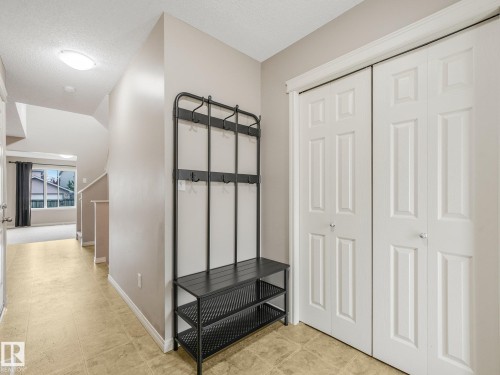 Entryway featuring light-toned tile flooring, neutral wall paint, and white paneled bi-fold closet doors - 11844 21 Avenue Sw, Edmonton, AB - Indoor Photo Showing Other Room