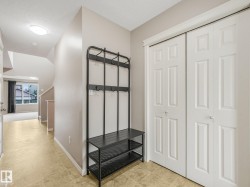 Entryway featuring light-toned tile flooring, neutral wall paint, and white paneled bi-fold closet doors - 