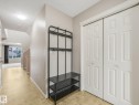 Entryway featuring light-toned tile flooring, neutral wall paint, and white paneled bi-fold closet doors - 11844 21 Avenue Sw, Edmonton, AB  - Indoor Photo Showing Other Room 
