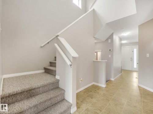 Carpeted staircase featuring a light gray palette and white handrails - 11844 21 Avenue Sw, Edmonton, AB - Indoor Photo Showing Other Room