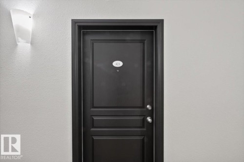 Dark paneled entry door with round door knobs and a door number plaque - #421 1180 Hyndman Rd Nw, Edmonton, AB -  Photo Showing Other Room