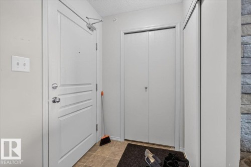 Entryway featuring a paneled door, bi-fold closet doors, and tile flooring - #421 1180 Hyndman Rd Nw, Edmonton, AB - Indoor Photo Showing Other Room