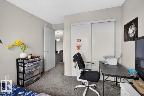 Carpeted room with neutral wall paint and a white closet featuring sliding doors - #421 1180 Hyndman Rd Nw, Edmonton, AB - Indoor