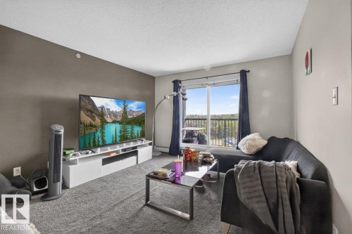 Living area with light gray carpeting and a neutral color palette - #421 1180 Hyndman Rd Nw, Edmonton, AB - Indoor