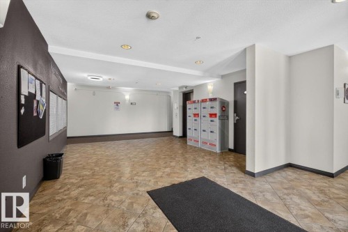 Building entryway featuring tile flooring, recessed lighting, and wall-mounted mailboxes - #421 1180 Hyndman Rd Nw, Edmonton, AB - Indoor Photo Showing Other Room