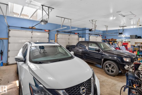 Expansive multi-bay garage featuring automatic overhead doors, a skylight, recessed lighting, and durable concrete flooring - 50336 Range Road 280, Rural Leduc County, AB - Indoor Photo Showing Garage