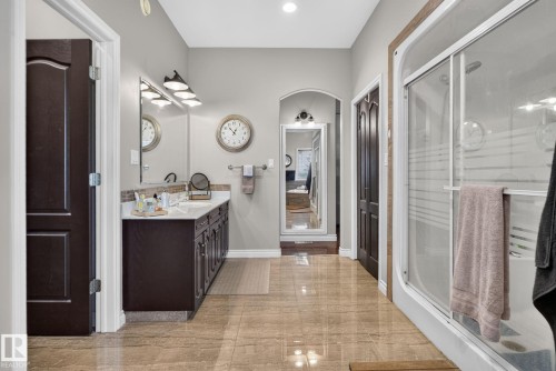 Spa-inspired primary bathroom suite featuring a double vanity with dark cabinetry, quartz countertop, and polished nickel fixtures - 50336 Range Road 280, Rural Leduc County, AB - Indoor Photo Showing Bathroom