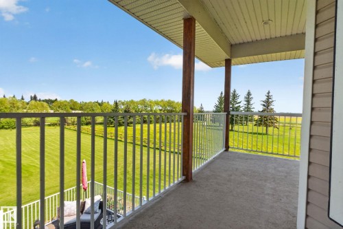 Upper-level balcony featuring concrete flooring, white metal railings, and natural wood support columns - 50336 Range Road 280, Rural Leduc County, AB - Outdoor With Exterior