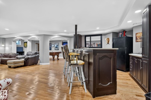 Entertainment area featuring a dark wood-finish bar with seating, recessed lighting, and wood-finish flooring - 50336 Range Road 280, Rural Leduc County, AB - Indoor