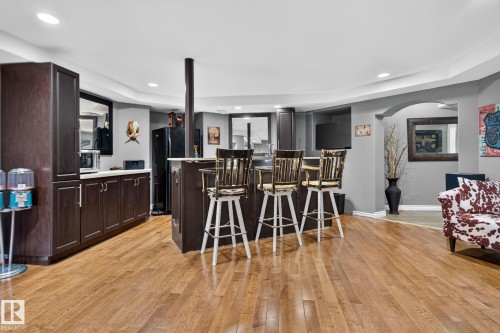 Entertainment area featuring wood-finish flooring, a built-in bar with dark cabinetry, a white countertop, and recessed lighting - 50336 Range Road 280, Rural Leduc County, AB - Indoor