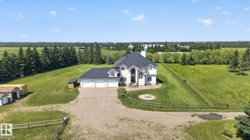 Sprawling estate featuring a grand stucco exterior, multi-car garage, and expansive manicured lawns - 50336 Range Road 280, Rural Leduc County, AB - Outdoor With View