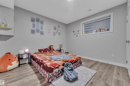 Neutral gray walls complement the wood-finish flooring in this space - 1809 18A Avenue Nw, Edmonton, AB - Indoor Photo Showing Bedroom