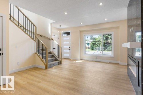 Bright and spacious open-concept living area featuring gleaming wood-finish flooring, recessed ceiling lighting, and abundant natural light from expansive windows - 10323 79 Street Nw, Edmonton, AB - Indoor Photo Showing Other Room