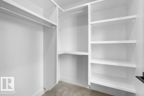 Walk-in closet with white shelving and hanging rods - 10323 79 Street Nw, Edmonton, AB - Indoor With Storage
