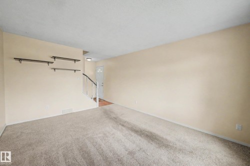 Spacious room featuring neutral carpeting and light-toned walls - 10032 173 Avenue Nw, Edmonton, AB - Indoor Photo Showing Other Room