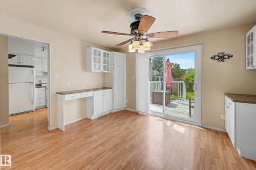 Open-concept area featuring wood-finish flooring, a ceiling fan with integrated lighting, and a sliding glass door providing access to an outdoor deck - 10032 173 Avenue Nw, Edmonton, AB - Indoor
