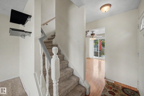Carpeted staircase featuring white balusters and a wood handrail - 10032 173 Avenue Nw, Edmonton, AB - Indoor Photo Showing Other Room