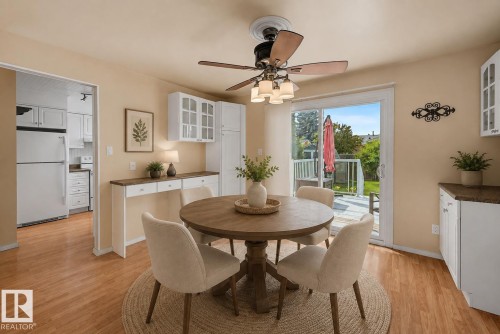 Open dining area showcases a round wood pedestal table positioned beneath a ceiling fan with integrated lighting - 10032 173 Avenue Nw, Edmonton, AB - Indoor Photo Showing Dining Room