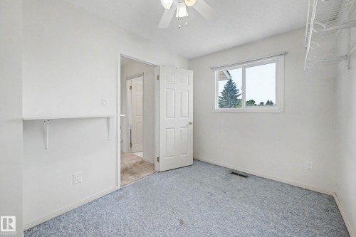 Bright bedroom with light blue carpeting, a white ceiling fan, and a window offering exterior views - 10032 173 Avenue Nw, Edmonton, AB - Indoor Photo Showing Other Room