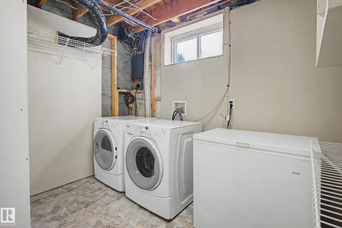 Dedicated laundry area with durable flooring, a window providing natural light, and exposed ceiling joists - 10032 173 Avenue Nw, Edmonton, AB - Indoor Photo Showing Laundry Room