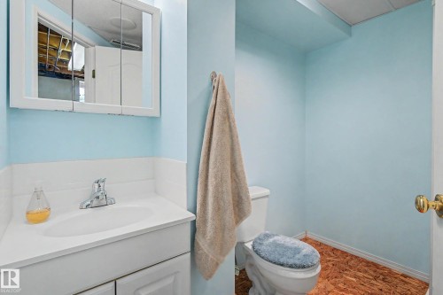 Bathroom featuring a white vanity with an integrated sink, chrome faucet, and a wall-mounted medicine cabinet with mirrored doors - 10032 173 Avenue Nw, Edmonton, AB - Indoor Photo Showing Bathroom