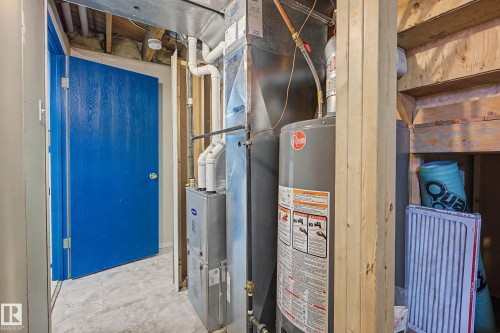 Utility area featuring a water heater, furnace, and exposed ceiling joists - 10032 173 Avenue Nw, Edmonton, AB - Indoor Photo Showing Basement