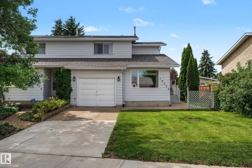 Two-story residence featuring light-colored siding, an attached single-car garage, and a concrete driveway - 10032 173 Avenue Nw, Edmonton, AB - Outdoor