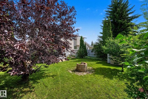 Expansive green lawn with a stone fire pit feature - 10032 173 Avenue Nw, Edmonton, AB - Outdoor