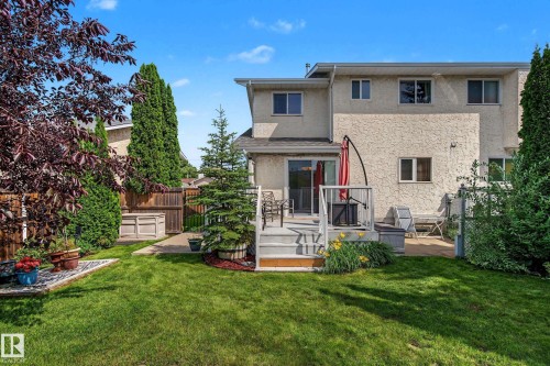 Expansive backyard featuring a manicured lawn, an elevated deck, and a concrete patio - 10032 173 Avenue Nw, Edmonton, AB - Outdoor