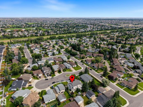 Aerial perspective showcasing a residential neighborhood with numerous detached homes, mature trees, and a clear blue sky - 10032 173 Avenue Nw, Edmonton, AB - Outdoor With View