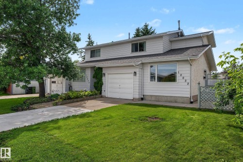 Two-story residence featuring light-colored siding, a dark shingled roof, and an attached garage with a white door - 10032 173 Avenue Nw, Edmonton, AB - Outdoor